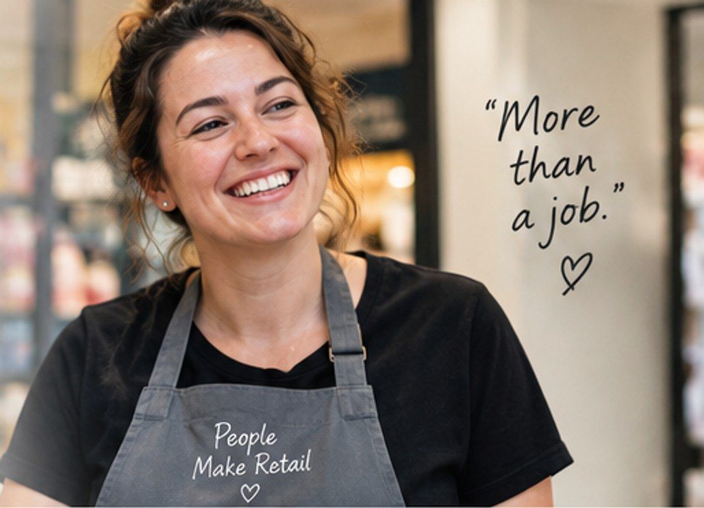 Temporary mock-up image: a smiling retail worker in an apron in a shop.